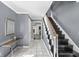 Inviting foyer features neutral walls, tiled flooring, and a staircase leading to the upper level, with a glimpse into the living area at 925 Forest Dr, Anderson, IN 46011