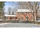Traditional brick home featuring a well-manicured lawn, mature trees, and covered porch, exuding timeless charm at 925 Forest Dr, Anderson, IN 46011