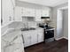 Kitchen featuring white cabinets, stainless steel appliances and marble countertops on a wood floor at 102 Plummer Ave, Bargersville, IN 46106