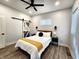 Bedroom features white walls, a ceiling fan, a sliding barn door, and a queen size bed at 1042 Nelson Ave, Indianapolis, IN 46203