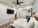 Bedroom with television, white queen bed with yellow blanket, and barn door feature at 1042 Nelson Ave, Indianapolis, IN 46203