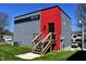 Modern home showcasing a red accent wall, a side entrance and gray siding at 1042 Nelson Ave, Indianapolis, IN 46203