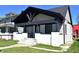 Charming home featuring a covered front porch with black trim and newly-painted stucco facade at 1042 Nelson Ave, Indianapolis, IN 46203