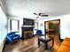 Open-concept living room with fireplace, ceiling fan, updated floors, modern furniture, and dining room access at 1042 Nelson Ave, Indianapolis, IN 46203