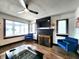 Cozy living room with a fireplace, large windows for natural light, ceiling fan, and comfortable seating at 1042 Nelson Ave, Indianapolis, IN 46203