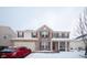 Charming two-story home with a brick facade, covered porch, and attached two-car garage on a snowy winter day at 1136 Meriman Dr, Greenwood, IN 46143