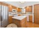 Cozy kitchen with wood cabinets, stainless steel refrigerator, and center island at 1232 Severn Ct, Greenwood, IN 46142