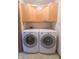 Functional laundry room with matching washer and dryer units and overhead storage cabinets at 1232 Severn Ct, Greenwood, IN 46142