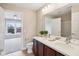 A charming bathroom with a double sink vanity leads to a bright bedroom at 13750 Hiatt Dr, Carmel, IN 46074