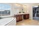 Bright bathroom with a soaking tub, large window, and dual sink vanity at 13750 Hiatt Dr, Carmel, IN 46074