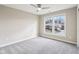 A sunlit bedroom features neutral walls, soft carpeting, and a ceiling fan for enhanced comfort at 13750 Hiatt Dr, Carmel, IN 46074