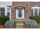 Close-up of the home's entryway, highlighting the blue front door, brick archway, and decorative shrubbery at 13750 Hiatt Dr, Carmel, IN 46074