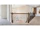 An upper hallway boasts a decorative chandelier and wrought iron railing overlooking the stairs at 13750 Hiatt Dr, Carmel, IN 46074