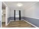 Formal dining room with wood-look floors, paneled accent wall, and modern light fixture at 1611 Orchard Ln, Anderson, IN 46011