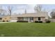 Single-story home with a stone exterior, an attached garage, and a beautifully manicured lawn at 1611 Orchard Ln, Anderson, IN 46011