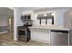 Kitchen showcasing stainless steel appliances, white cabinets, modern flooring and countertop, and a breakfast bar at 1611 Orchard Ln, Anderson, IN 46011