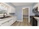 Remodeled kitchen featuring stainless steel oven, microwave, white cabinets, and stone countertops at 1611 Orchard Ln, Anderson, IN 46011