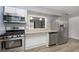 Kitchen with stainless steel appliances, white cabinets, modern flooring and countertop, and a breakfast bar at 1611 Orchard Ln, Anderson, IN 46011