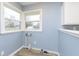 Laundry room features blue walls, two large windows and modern flooring at 1611 Orchard Ln, Anderson, IN 46011