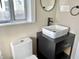 A bathroom featuring a white vessel sink, a black vanity, and a round mirror at 1640 Bellefontaine St, Indianapolis, IN 46202