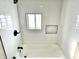 A bathroom featuring a white tub, tiled walls, and a recessed shower niche at 1640 Bellefontaine St, Indianapolis, IN 46202