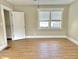 Bright bedroom with wood-look flooring, white trim, and a bright window at 1640 Bellefontaine St, Indianapolis, IN 46202