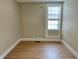 Bedroom featuring wood-look floors, neutral walls, a window and white trim throughout at 1640 Bellefontaine St, Indianapolis, IN 46202