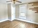 Bright bedroom featuring wood-look floors, neutral walls, a ceiling fan, and a window at 1640 Bellefontaine St, Indianapolis, IN 46202