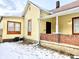 A detailed side view of the home exterior showing windows with red trim and a covered front porch at 1640 Bellefontaine St, Indianapolis, IN 46202