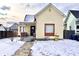 Image of a cream two-story home featuring red trim, covered porch, and a snowy yard at 1640 Bellefontaine St, Indianapolis, IN 46202