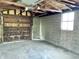 Interior shot of the garage showing the door and cinderblock wall, with visible rafters at 1640 Bellefontaine St, Indianapolis, IN 46202