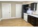 A kitchen with dark brown cabinets, wood-look flooring, a white stove, and two white doors at 1640 Bellefontaine St, Indianapolis, IN 46202