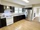 A spacious kitchen featuring wood-look flooring, dark cabinets, and stainless steel appliances at 1640 Bellefontaine St, Indianapolis, IN 46202