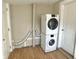 Functional laundry area features a stacked washer/dryer, utility fixtures, and wood-look flooring at 1640 Bellefontaine St, Indianapolis, IN 46202