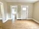 Open living room area showing wood-look floors, front door and light filled doorway at 1640 Bellefontaine St, Indianapolis, IN 46202