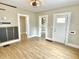 Open living room with wood-look floors, showing front door and light-filled doorway at 1640 Bellefontaine St, Indianapolis, IN 46202