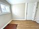 An empty room features a window, an entry door, wood-look flooring, and access to crawl space at 1640 Bellefontaine St, Indianapolis, IN 46202