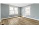 Bedroom with two large windows allowing natural light and beautiful new wood flooring at 19 Parkview Ave, Indianapolis, IN 46201