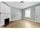 Cozy living room with fireplace, hardwood flooring, and a bright window at 19 Parkview Ave, Indianapolis, IN 46201
