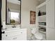 Bright bathroom featuring a white vanity, black framed mirror, and view to the exterior at 2071 Eagle Trace Dr, Greenwood, IN 46143