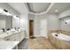 Bathroom with a soaking tub, double vanity with vessel sinks, and modern lighting fixtures at 2071 Eagle Trace Dr, Greenwood, IN 46143