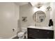 Stylish powder room featuring a round mirror, dark vanity, and modern fixtures at 2071 Eagle Trace Dr, Greenwood, IN 46143