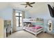 Bright bedroom featuring a bunk bed, desk, ceiling fan, and a large window at 2071 Eagle Trace Dr, Greenwood, IN 46143