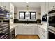 Modern kitchen features white cabinets, stainless steel appliances, a farmhouse sink, and a beverage center at 2071 Eagle Trace Dr, Greenwood, IN 46143