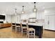 Open kitchen features a large island with pendant lighting, stainless steel appliances, and light wood flooring at 2071 Eagle Trace Dr, Greenwood, IN 46143