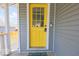 Charming yellow front door with glass panes and welcoming 'hello' decal at 401 E Ohio St, Fortville, IN 46040