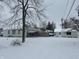 Wide backyard view of the home, outbuilding, and garage during winter at 504 E Walnut St, Summitville, IN 46070