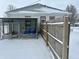 View of the backyard featuring a partially covered structure and wooden fence, covered in snow at 504 E Walnut St, Summitville, IN 46070