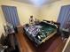 Bedroom featuring hardwood floors, a queen sized bed, and blue curtains at 504 E Walnut St, Summitville, IN 46070