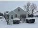Charming home featuring gray siding, red trim, and inviting front porch in winter at 504 E Walnut St, Summitville, IN 46070